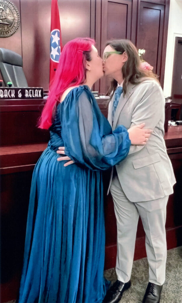 A photo of Joe Hills and Lauryn Hills kissing in a couthouse. 